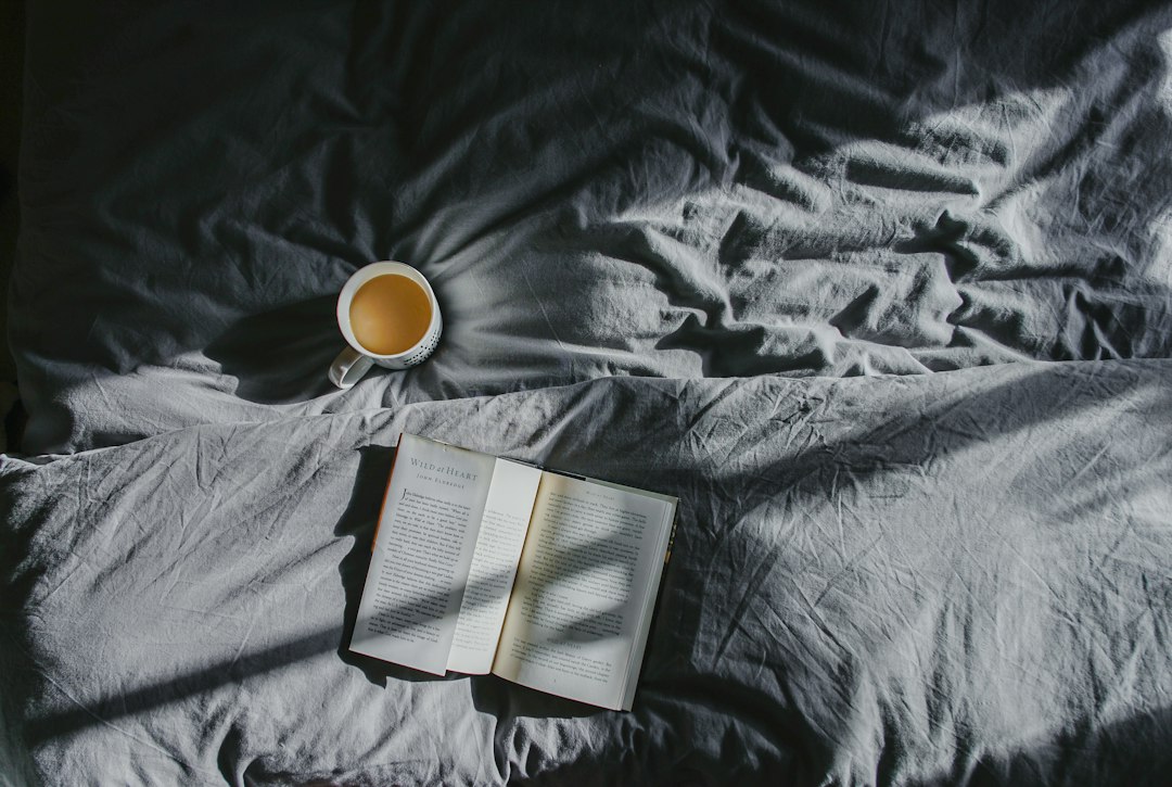 A cup of tea and an open book beside a window, representing a calm and repeatable daily habit.