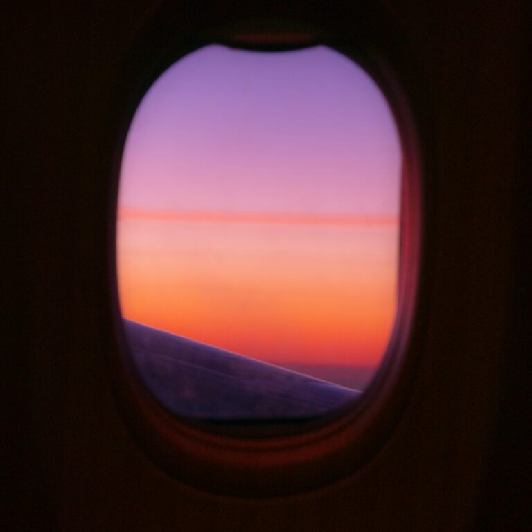A warm sunset seen through an airplane window. Photograph by Nils Mahler on Unsplash.